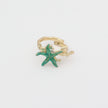 Astel Ring close-up — handmade brass ring with faceted crystal stone set between starfish and coral detail
