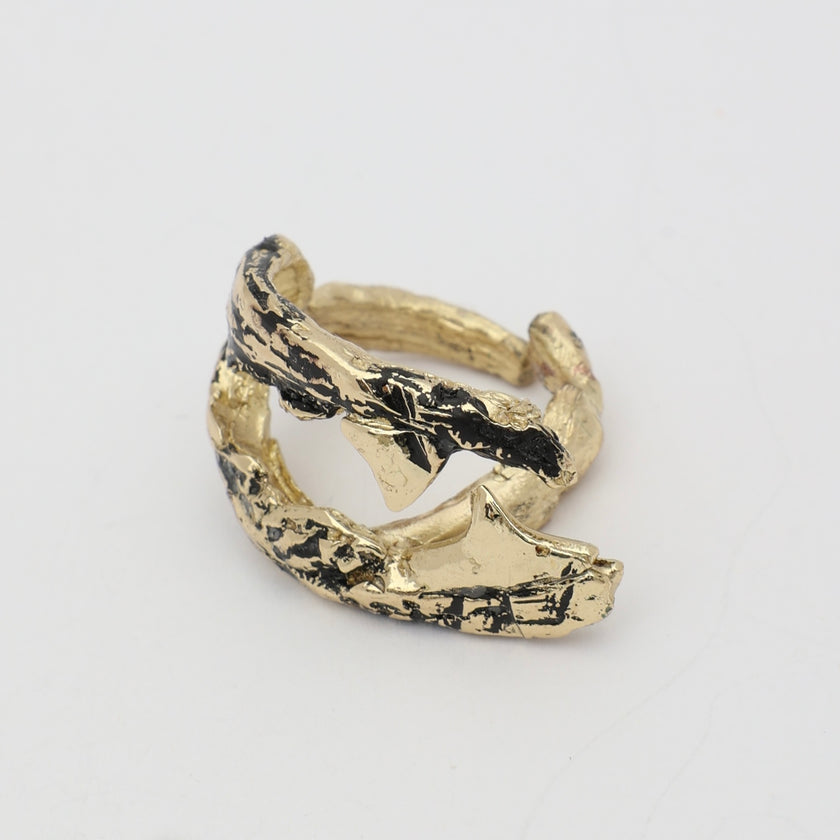 Claw Ring side view — handmade brass ring with deeply grooved barnacle-texture surface and tapered open ends