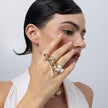 Brass statement ring with pearl and crystal branch design, worn close-up
