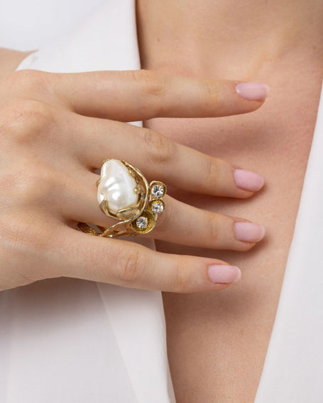 Handmade brass pearl statement ring worn on hand, close-up
