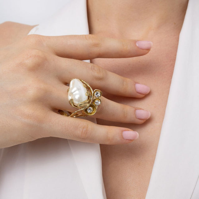 Handmade brass pearl statement ring worn on hand, close-up