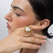 Handmade brass pearl statement ring worn on hand, close-up, Bubblegum