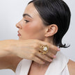 Brass pearl nest ring worn on finger against neck, side profile, Bubblegum