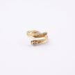 Glade gold open statement ring with sculpted leaf-shaped ends and baguette crystal, side view on white background