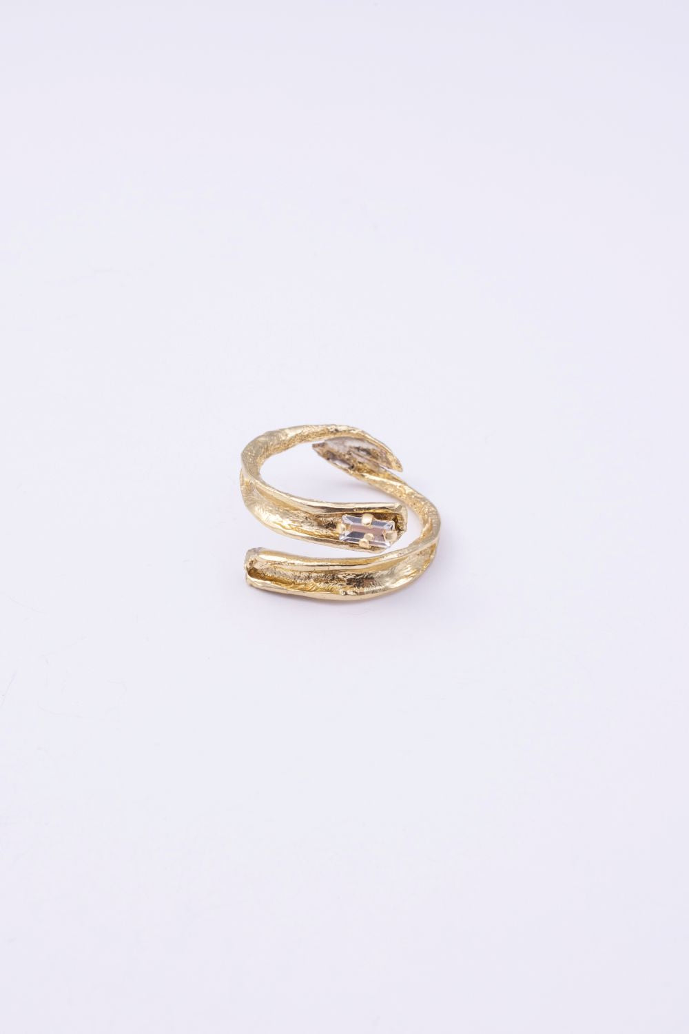  Glade handmade gold-plated brass wrap ring with organic texture and clear baguette-cut crystal on a white background