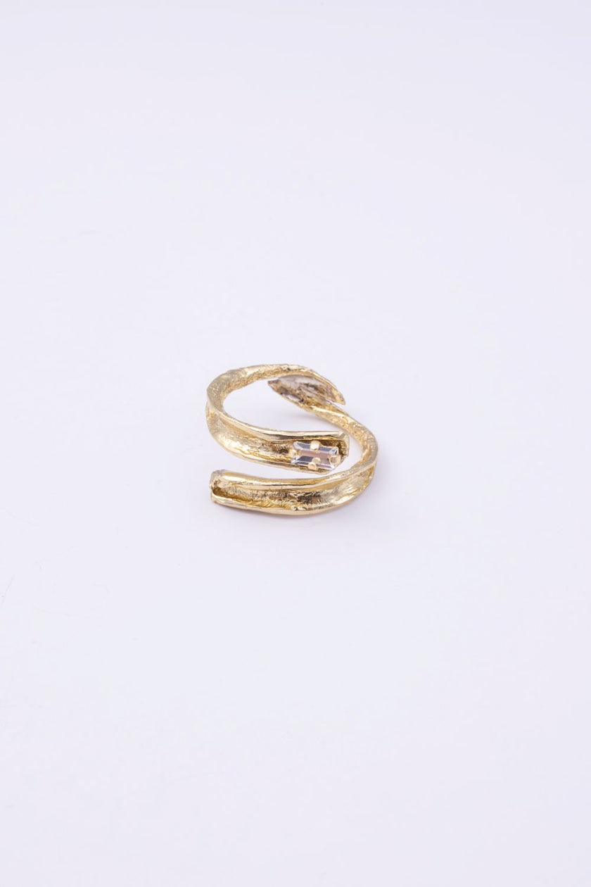  Glade handmade gold-plated brass wrap ring with organic texture and clear baguette-cut crystal on a white background