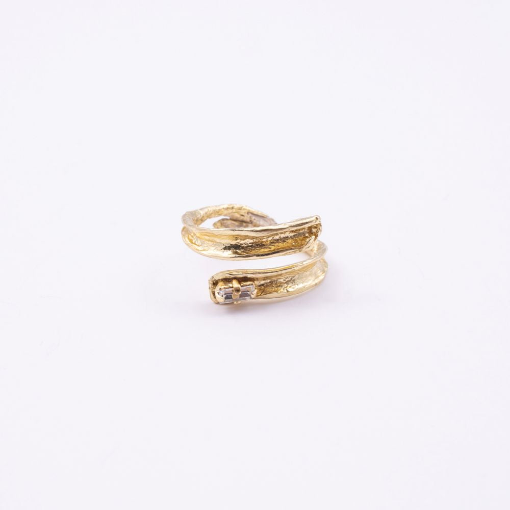 Glade gold open statement ring with sculpted leaf-shaped ends and baguette crystal, side view on white background