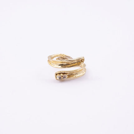 Glade gold open statement ring with sculpted leaf-shaped ends and baguette crystal, side view on white background