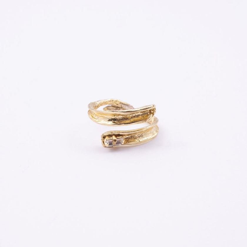 Glade gold open statement ring with sculpted leaf-shaped ends and baguette crystal, side view on white background