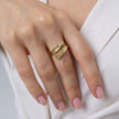 Woman wearing the Glade gold-plated wrap ring with textured leaf-like ends and a baguette crystal, Savage Flora