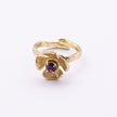 Posy Ring — handmade brass flower ring with ruffled petals and faceted crystal stone on white background