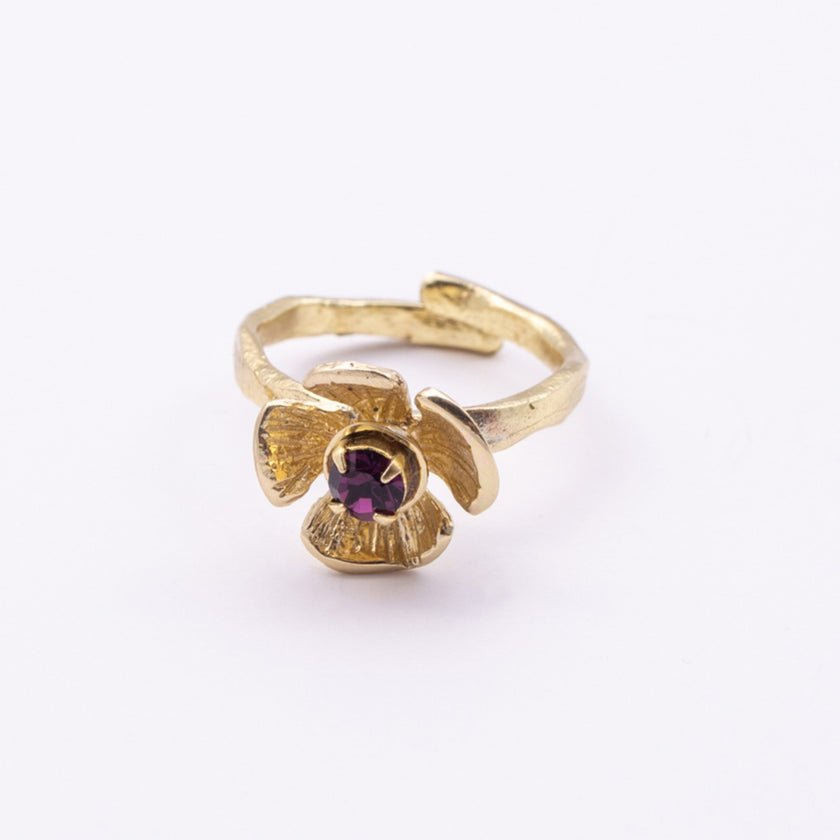 Posy Ring — handmade brass flower ring with ruffled petals and faceted crystal stone on white background