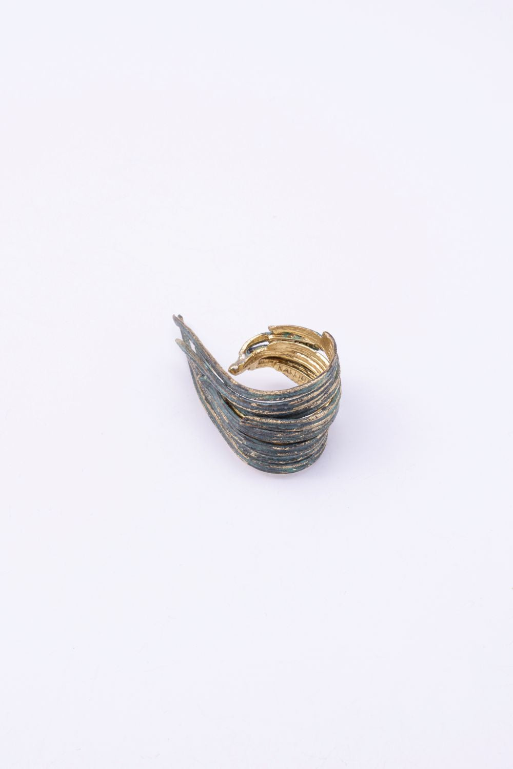 Pine green patina wrap statement ring with layered textured bands, angled view on white background