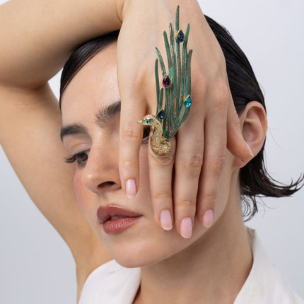 Model wearing the Peacock cocktail ring with green patina feathers and blue, purple and turquoise teardrop crystals, Savage Flora