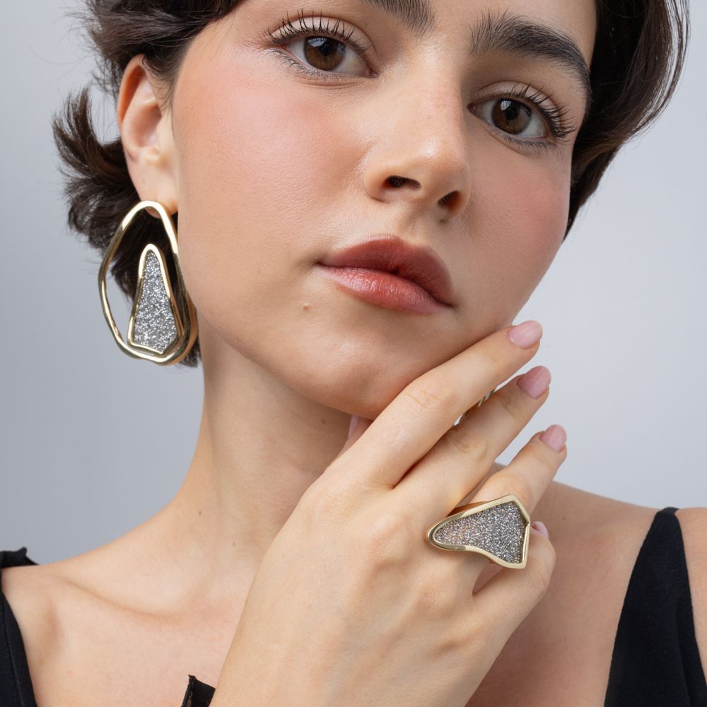 Model wearing Glitter Kiss gold crystal ring with matching open-frame crystal earrings