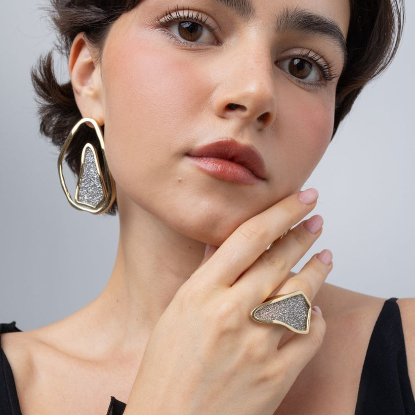 Model wearing Glitter Kiss gold crystal ring with matching open-frame crystal earrings