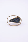 Front view of open frame gold ring with asymmetric compressed crystal panel