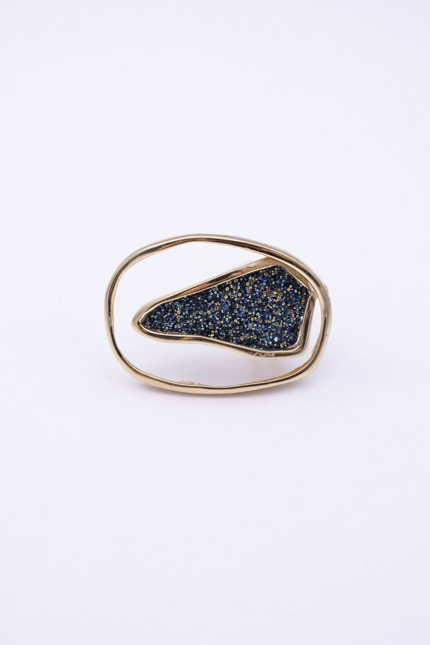 Front view of open frame gold ring with asymmetric compressed crystal panel