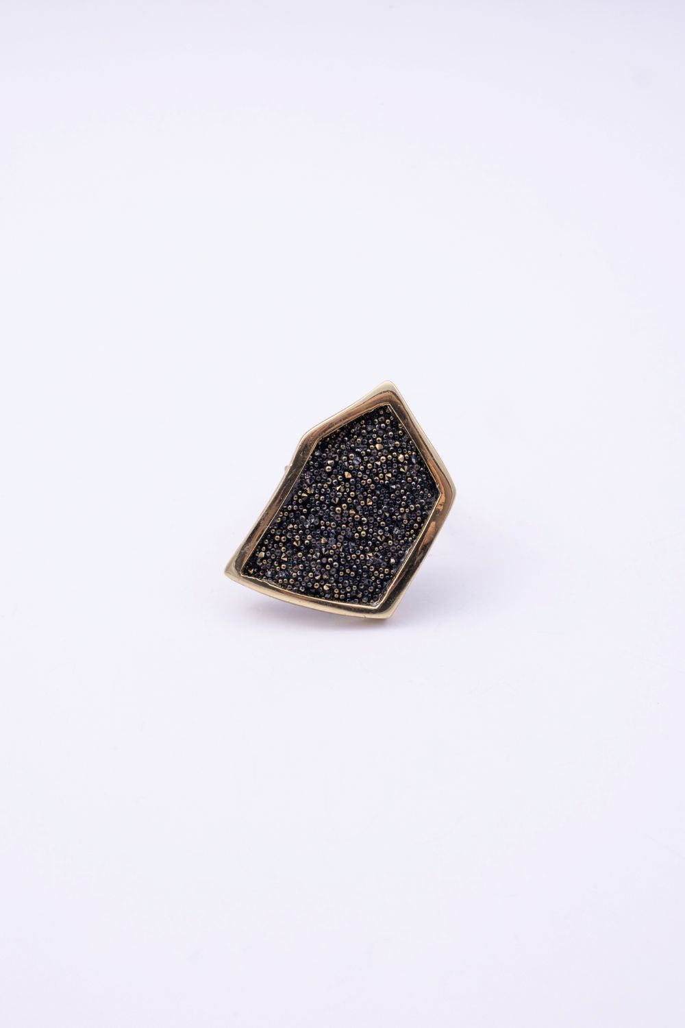 Top view of angular gold crystal ring with textured crystal panel