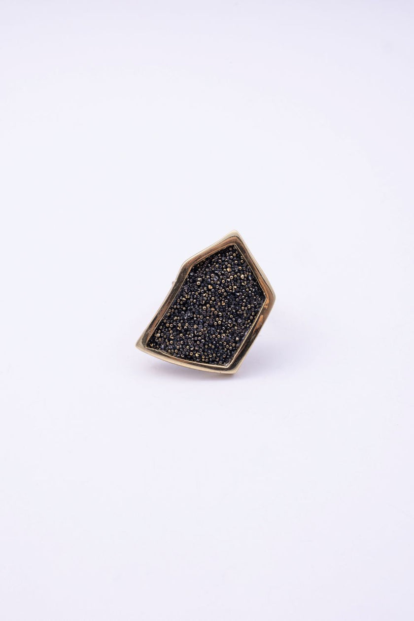 Top view of angular gold crystal ring with textured crystal panel