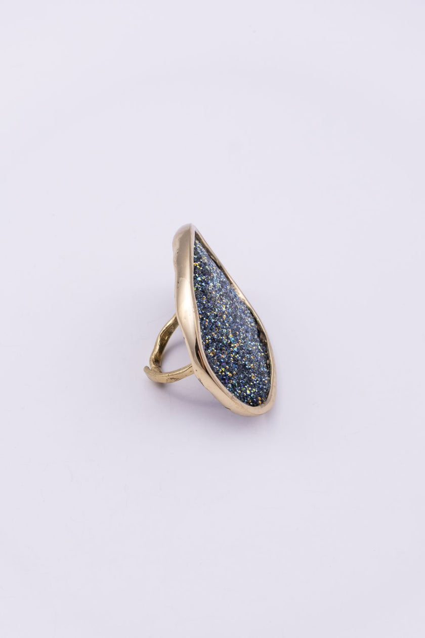 Side view of handmade gold ring with oval crystal surface and hammered open band