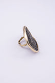 Angled view of sculptural gold crystal ring showing the textured band