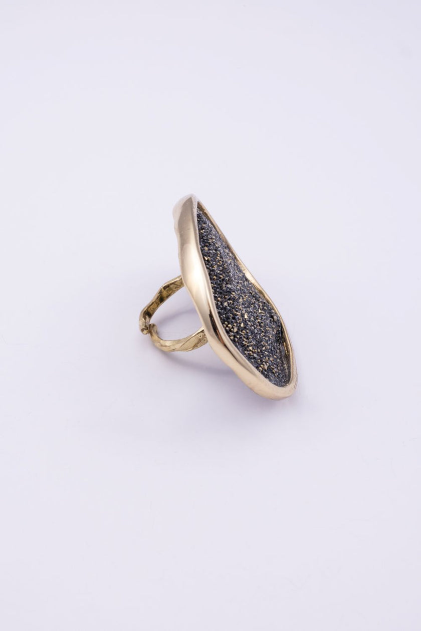 Angled view of sculptural gold crystal ring showing the textured band