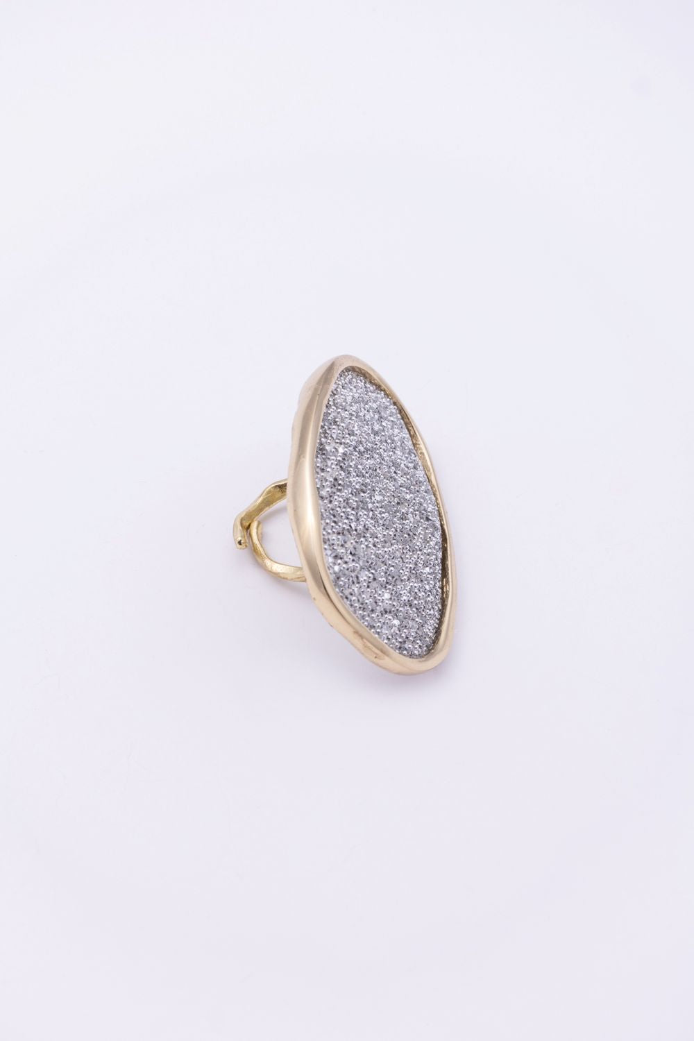 Side profile of gold oval statement ring with open hammered band