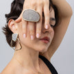 Model wearing Glitter Kiss oval crystal ring with matching geometric crystal earrings and gold necklace