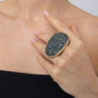 Close-up of oversized oval crystal statement ring on the index finger, Glitter Kiss collection