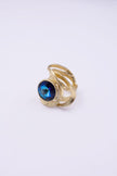 Model wearing the Shiny Boteh gold ring with iridescent blue crystal, with matching earrings and necklace, Savage Flora