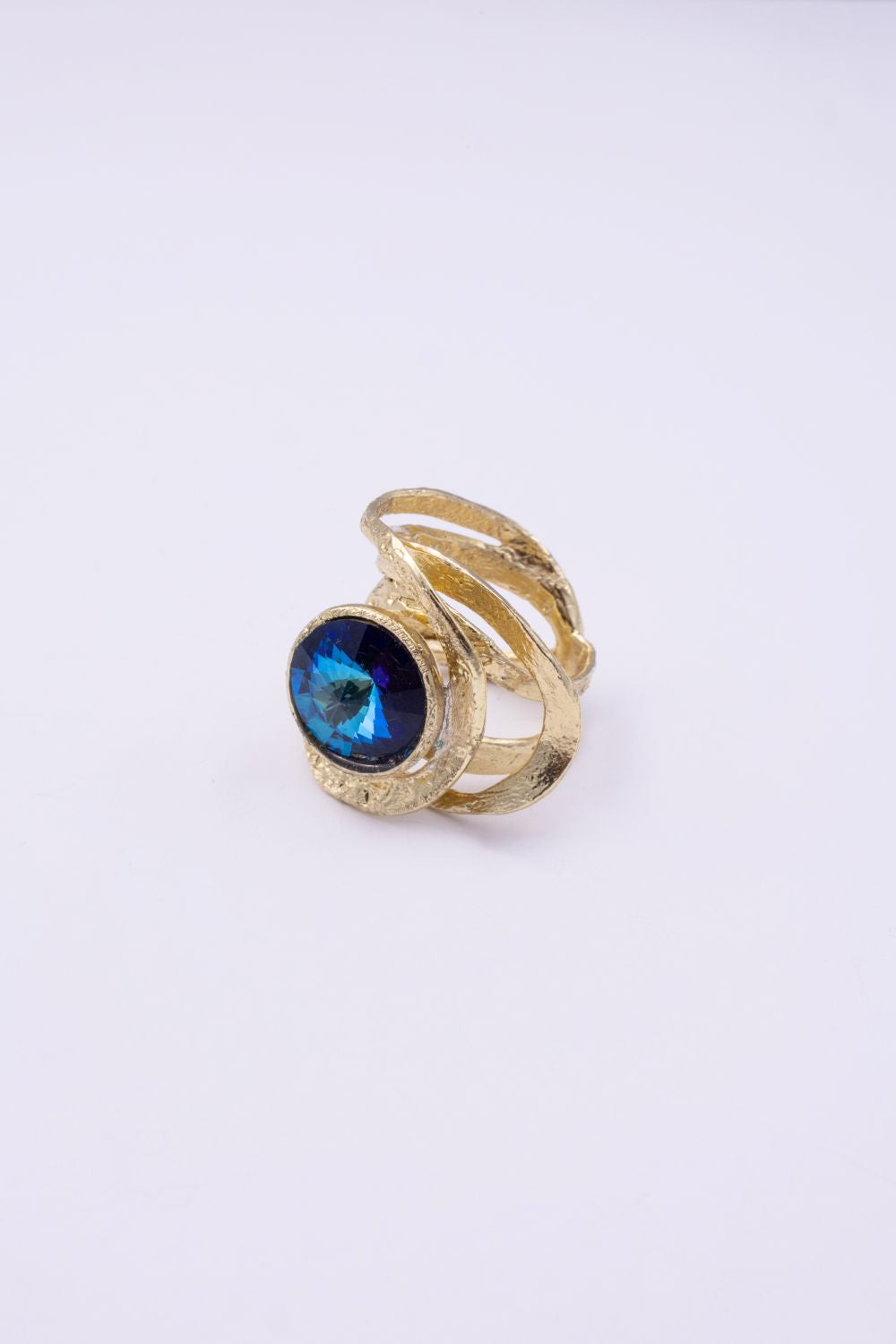 Model wearing the Shiny Boteh gold ring with iridescent blue crystal, with matching earrings and necklace, Savage Flora