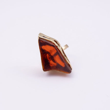 Kite handmade gold-plated statement ring with a large amber raw-cut stone in a sculptural gold setting on a white background