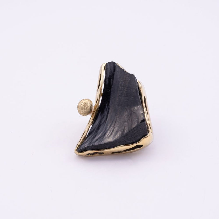 Kate black resin statement ring in a gold frame with organic cut-outs, front view on white background