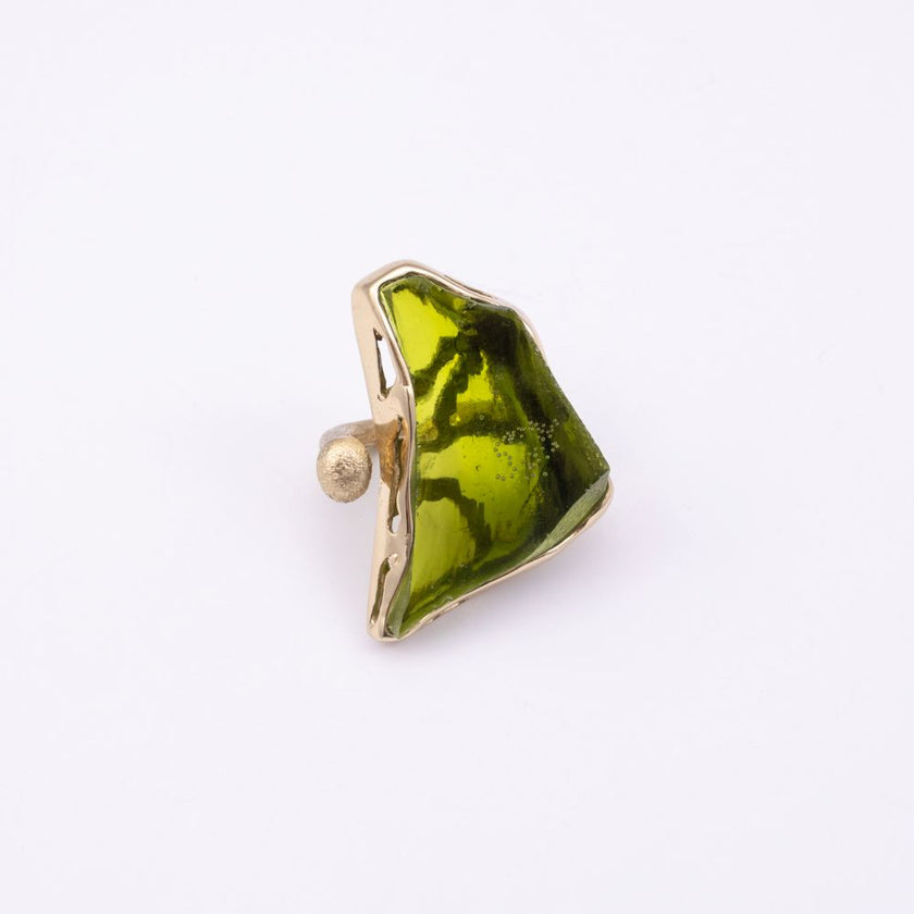 Kate gold-plated brass cocktail ring with a large olive green resin stone in a sculptural gold frame, front view on white background