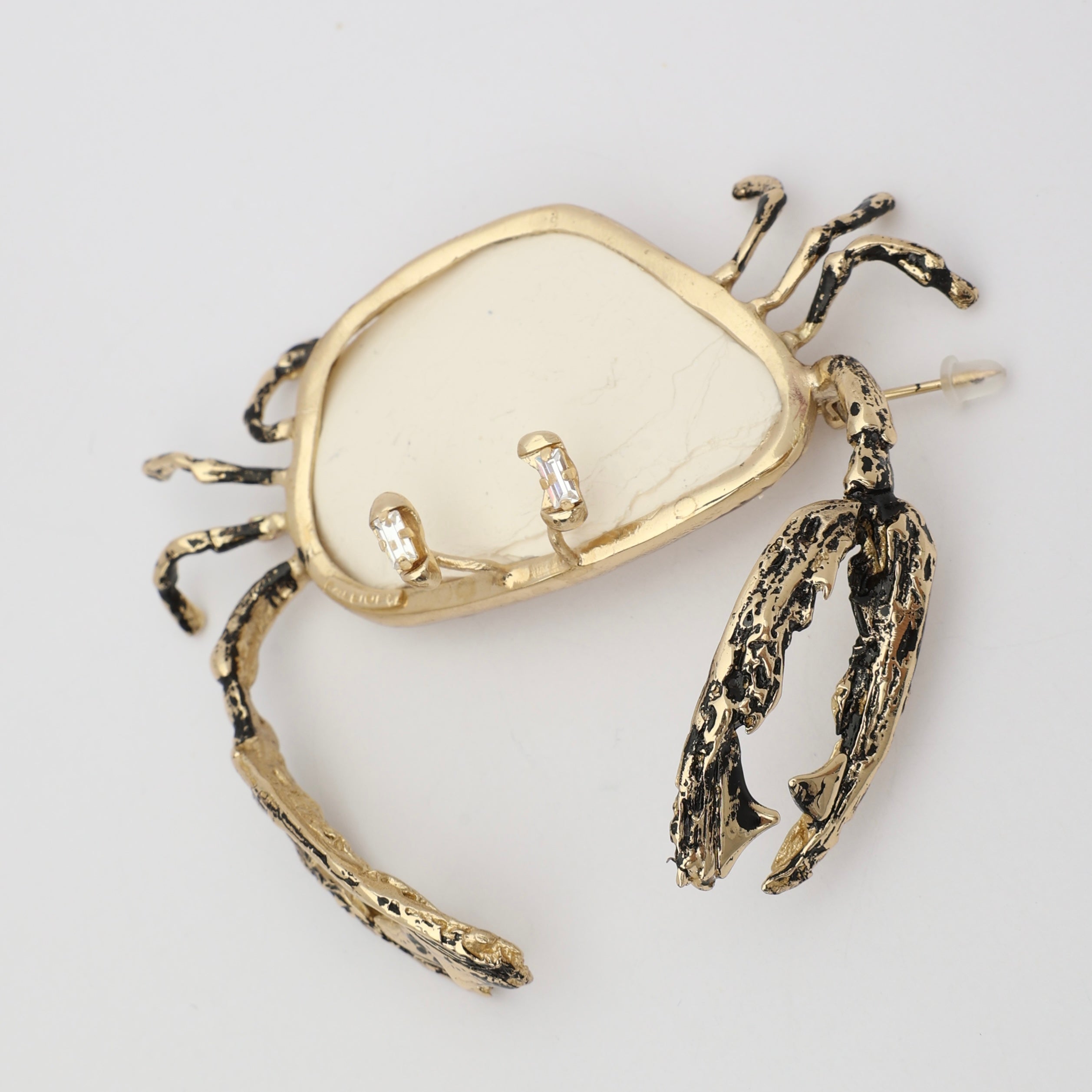 Crasta Pin — handmade brass crab shaped pin with resin stone and crystal eyes on white background