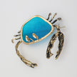 Crasta Pin close-up — handmade brass sculptural crab brooch with textured pincers and resin stone detail
