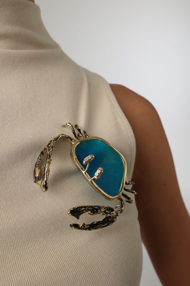 Crasta Pin detail — handmade brass artisan brooch with crystal accents and organic texture