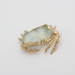 Crabby Pin — handmade brass crab shaped pin with translucent resin stone on white background
