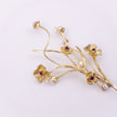 Brass floral brooch with pearl stems and crystal flowers, side angle
