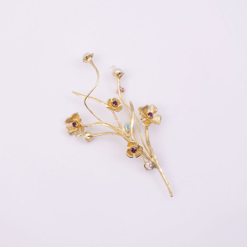 Brass flower brooch with amethyst and iridescent crystal detail, product shot