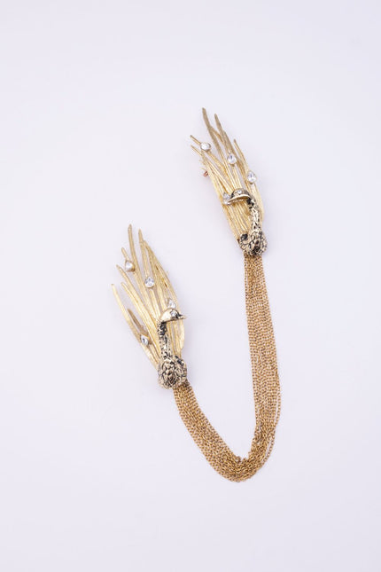 Peacock gold-plated brass double brooch with black oxidized peacock, clear crystals and gold chain on a white background