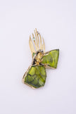 Plume handmade gold-plated peacock statement pin with olive green resin stones and crystal feather tips on a white background