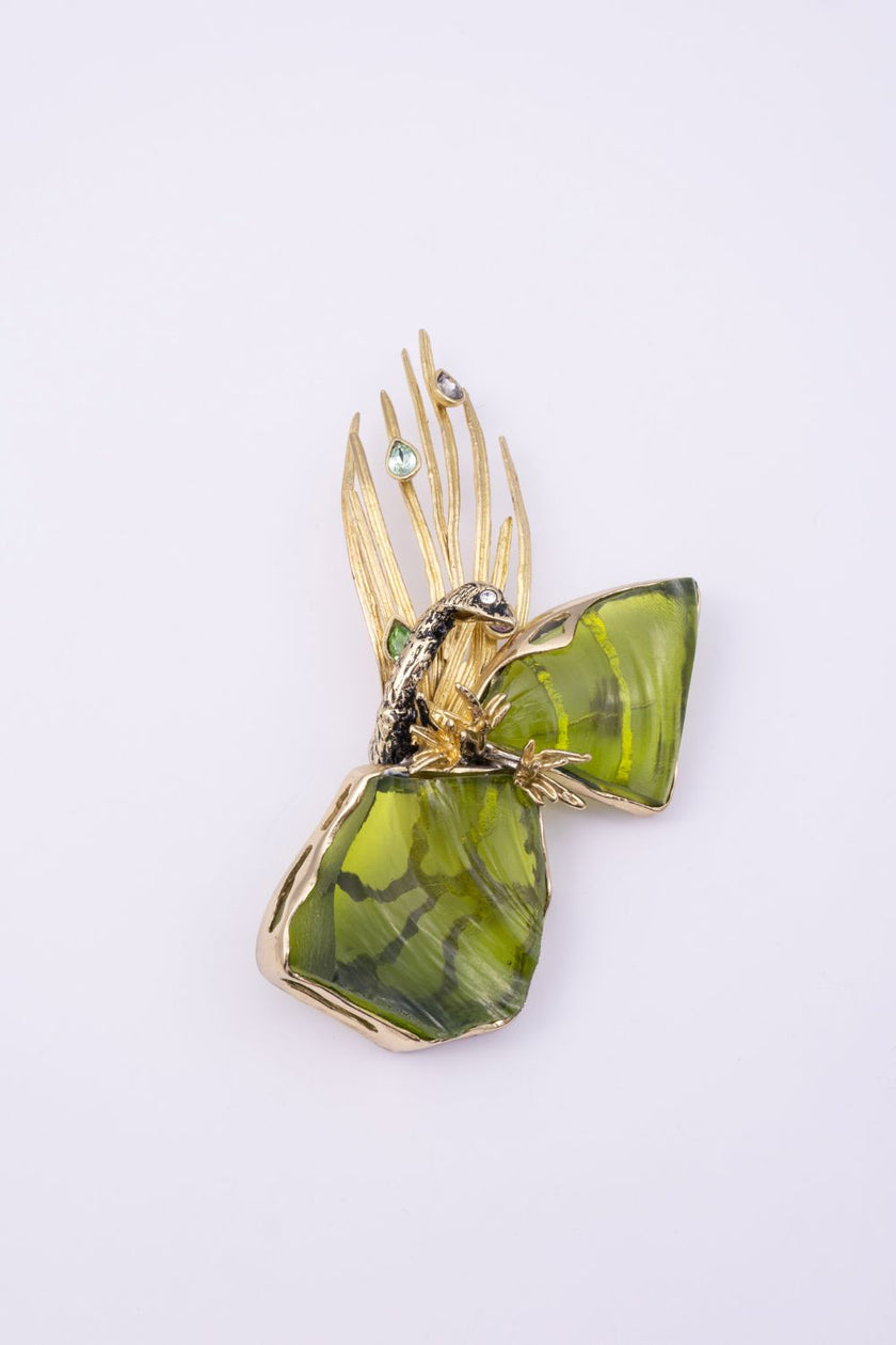 Plume handmade gold-plated peacock statement pin with olive green resin stones and crystal feather tips on a white background