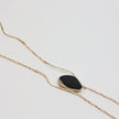 Elemental Pebble Necklace — handmade brass wavy chain necklace laid flat on white background, full length