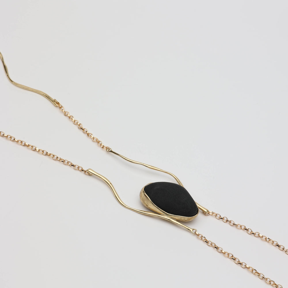 Elemental Pebble Necklace — handmade brass wavy chain necklace laid flat on white background, full length