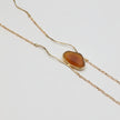 Elemental Pebble Necklace — handmade brass long necklace with resin stone pendant, front view on white background