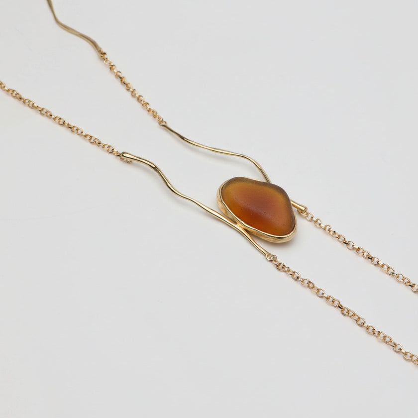 Elemental Pebble Necklace — handmade brass long necklace with resin stone pendant, front view on white background