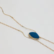 Elemental Pebble Necklace — handmade brass necklace with raw resin stone pendant, top down view on white background