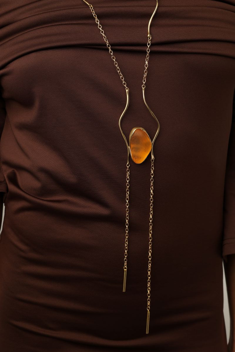 Elemental Pebble Necklace flat lay — handmade brass long necklace with resin stone pendant, full view